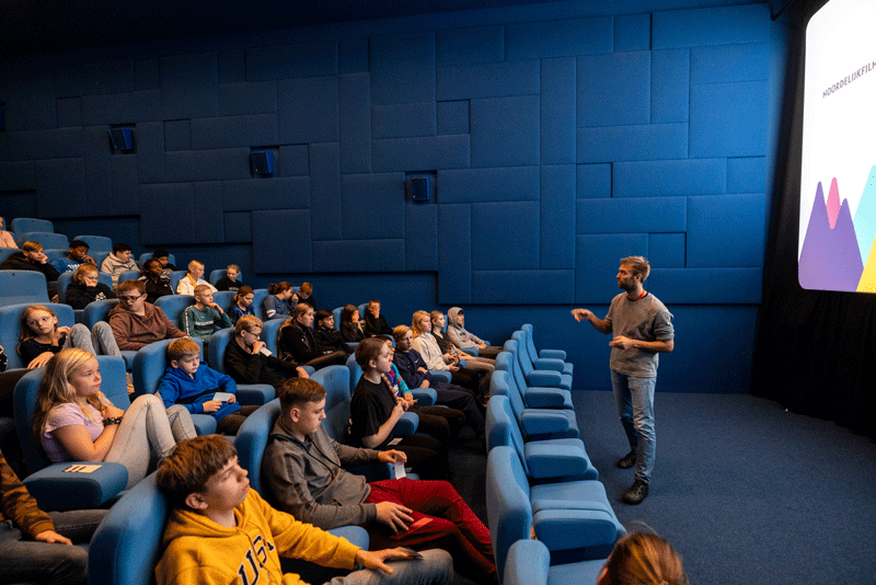 Man geeft presentatie aan schoolklas in een filmzaal Noordelijk Film Festival